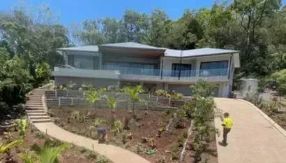 Modern house with a new concrete sleeper retaining wall, landscaped garden and exposed aggregate path installed