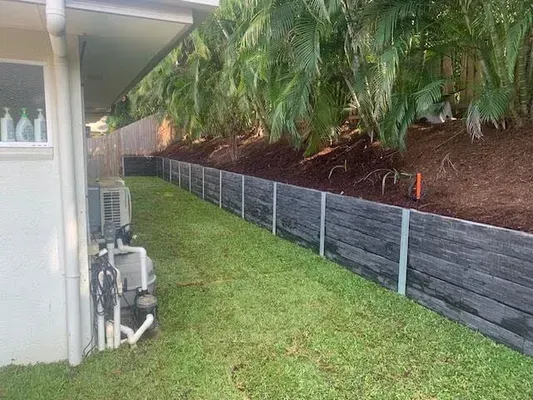 Concrete sleeper retaining wall along the side yard of a Cairns home