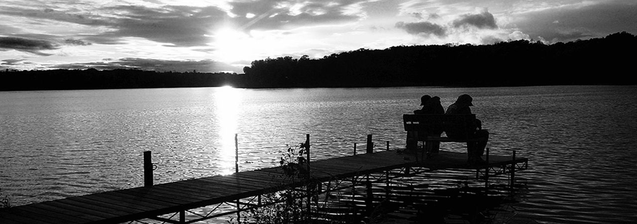 Family watching the sunset from a lakeside pier near Reedsburg