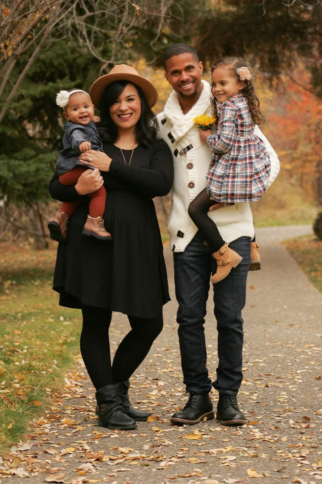 A family is posing for a picture on a path in a park.