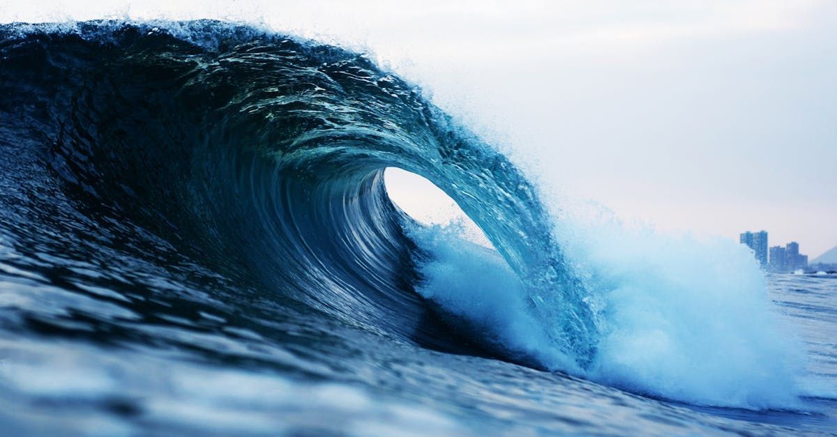 A large wave in the ocean is breaking on the shore.