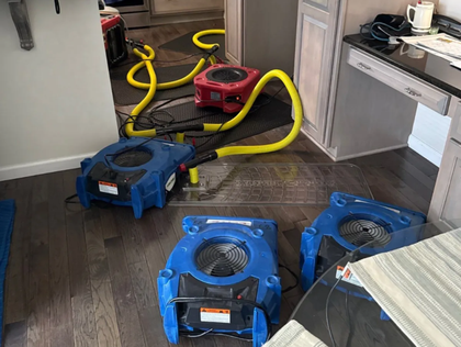 Three carpet dryers with yellow hoses in a room after water damage cleanup