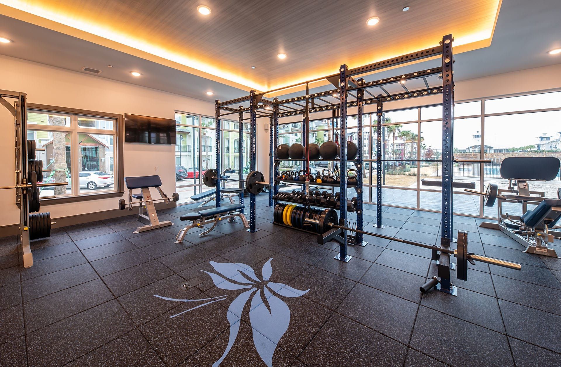 A gym with a lot of treadmills and a ceiling fan