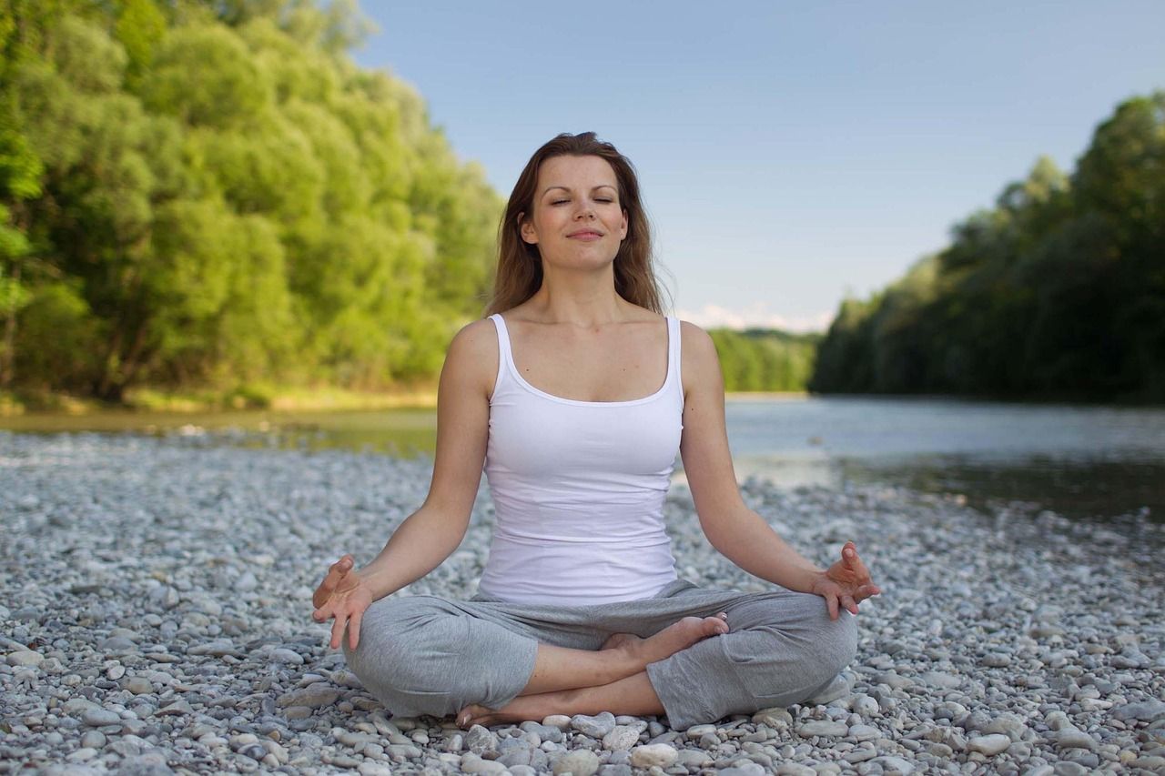 Lady meditating next to a river