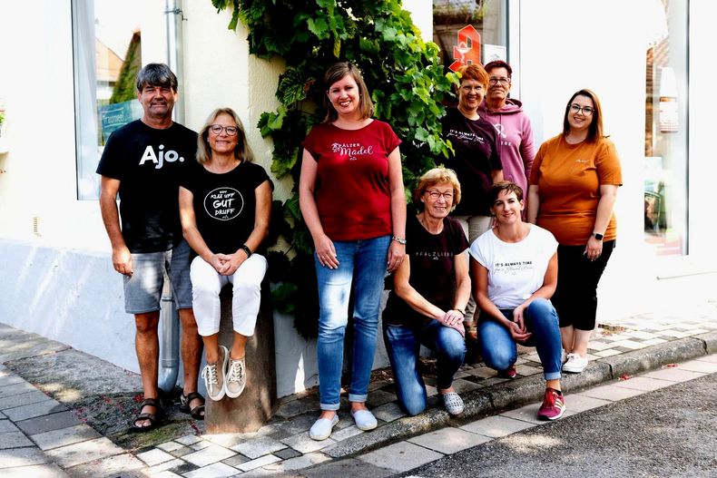 Eine Gruppe von Menschen posiert vor einem Gebäude für ein Foto.