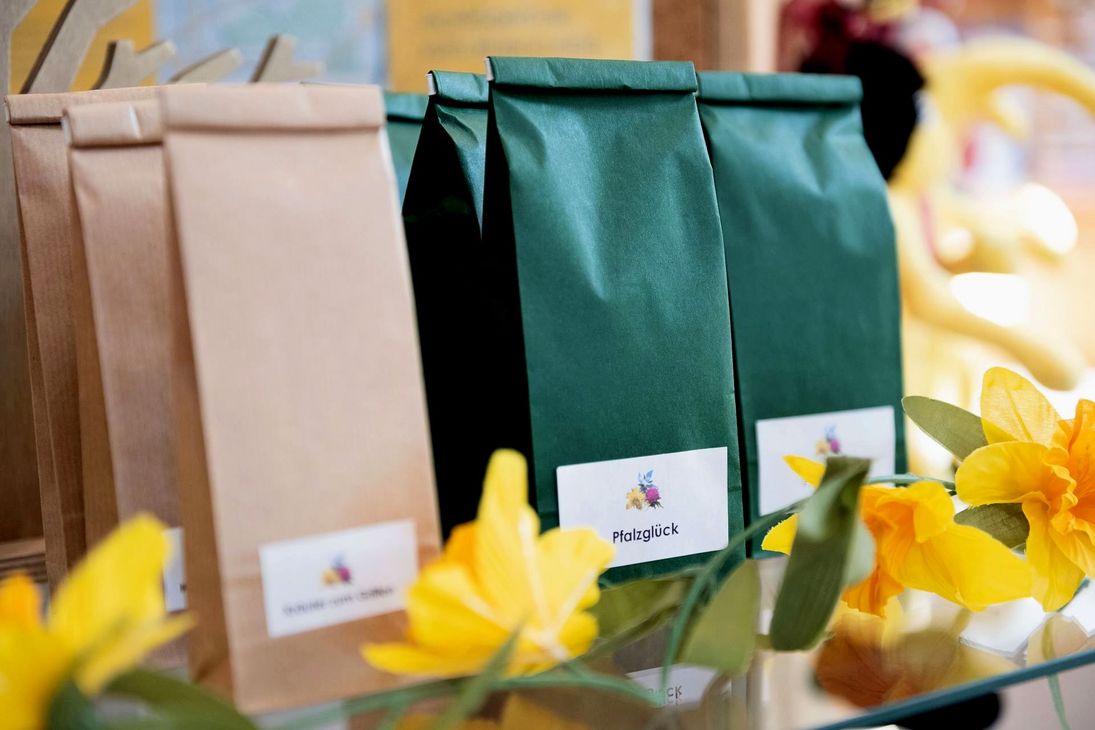 Ein Bündel Taschen liegt auf einem Tisch mit gelben Blumen im Hintergrund
