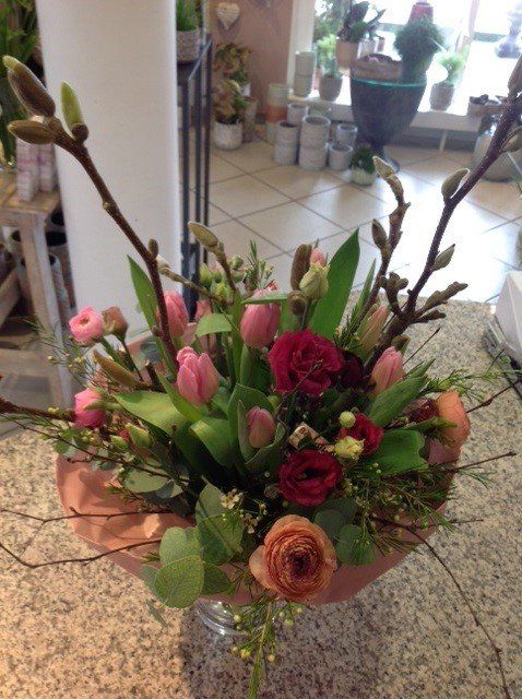 Eine mit Blumen gefüllte Vase steht auf einer Theke