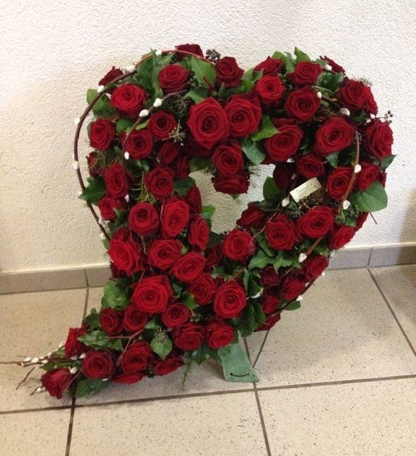 Ein herzförmiger Kranz aus roten Rosen und Grün
