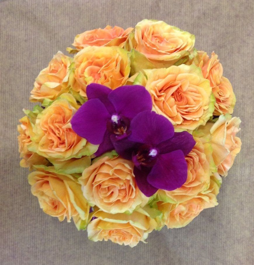 Ein Strauß orangefarbener Rosen und lila Orchideen