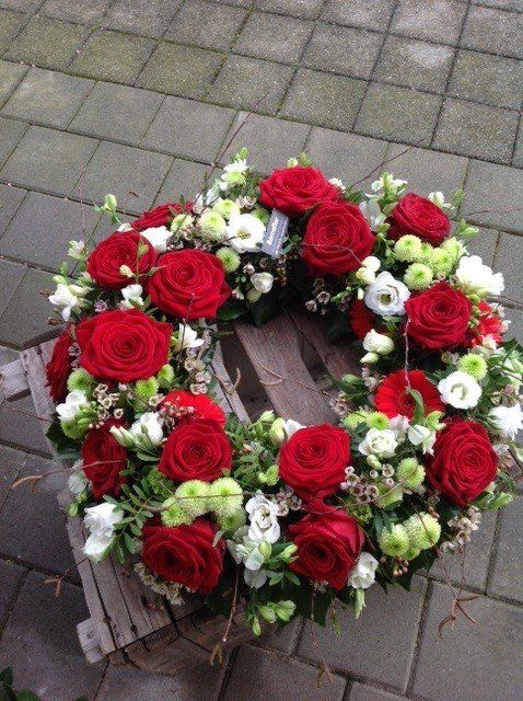Ein Kranz aus roten Rosen und weißen Blumen