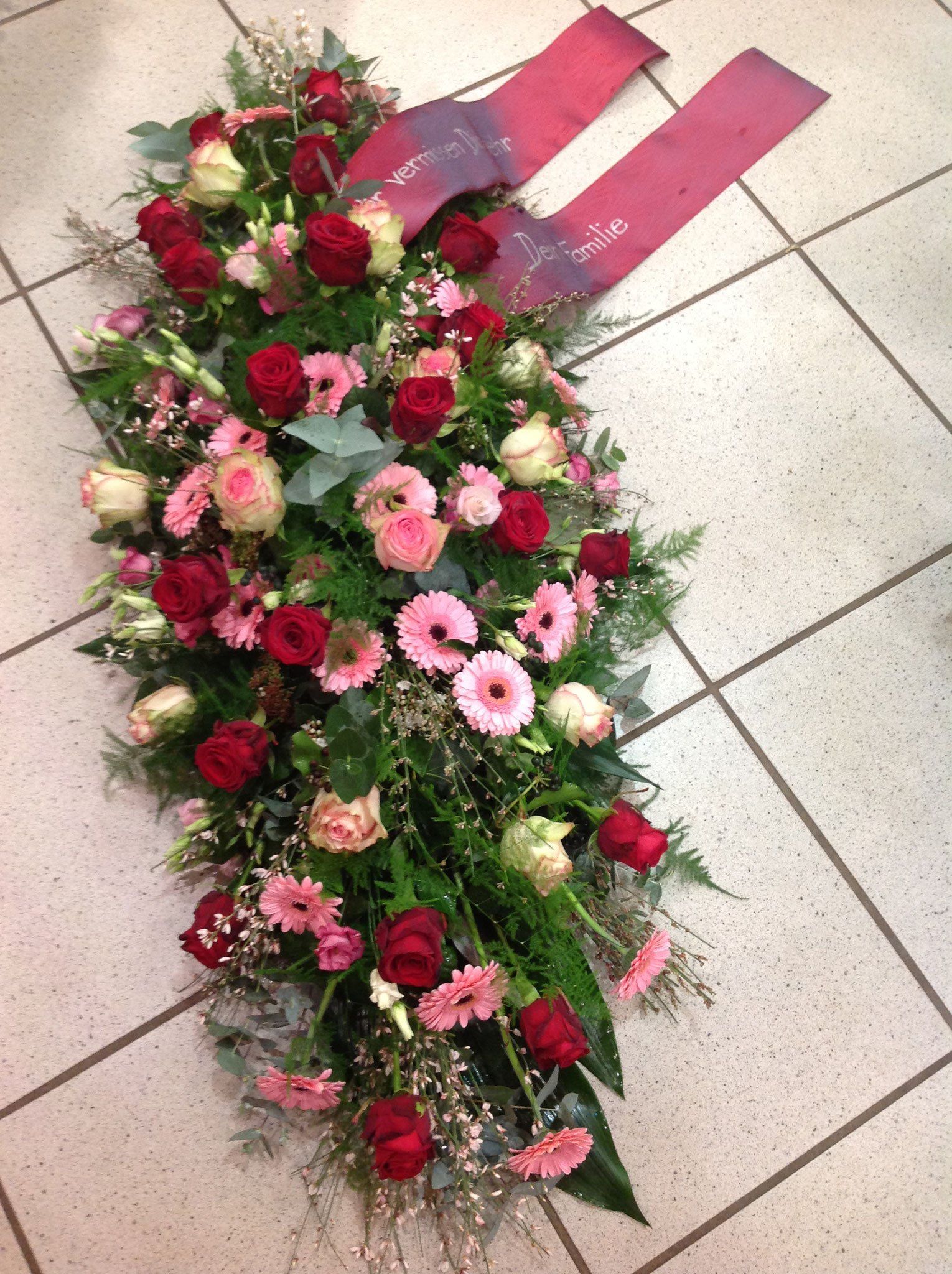 Ein Blumenstrauß mit einer roten Schleife auf dem Boden
