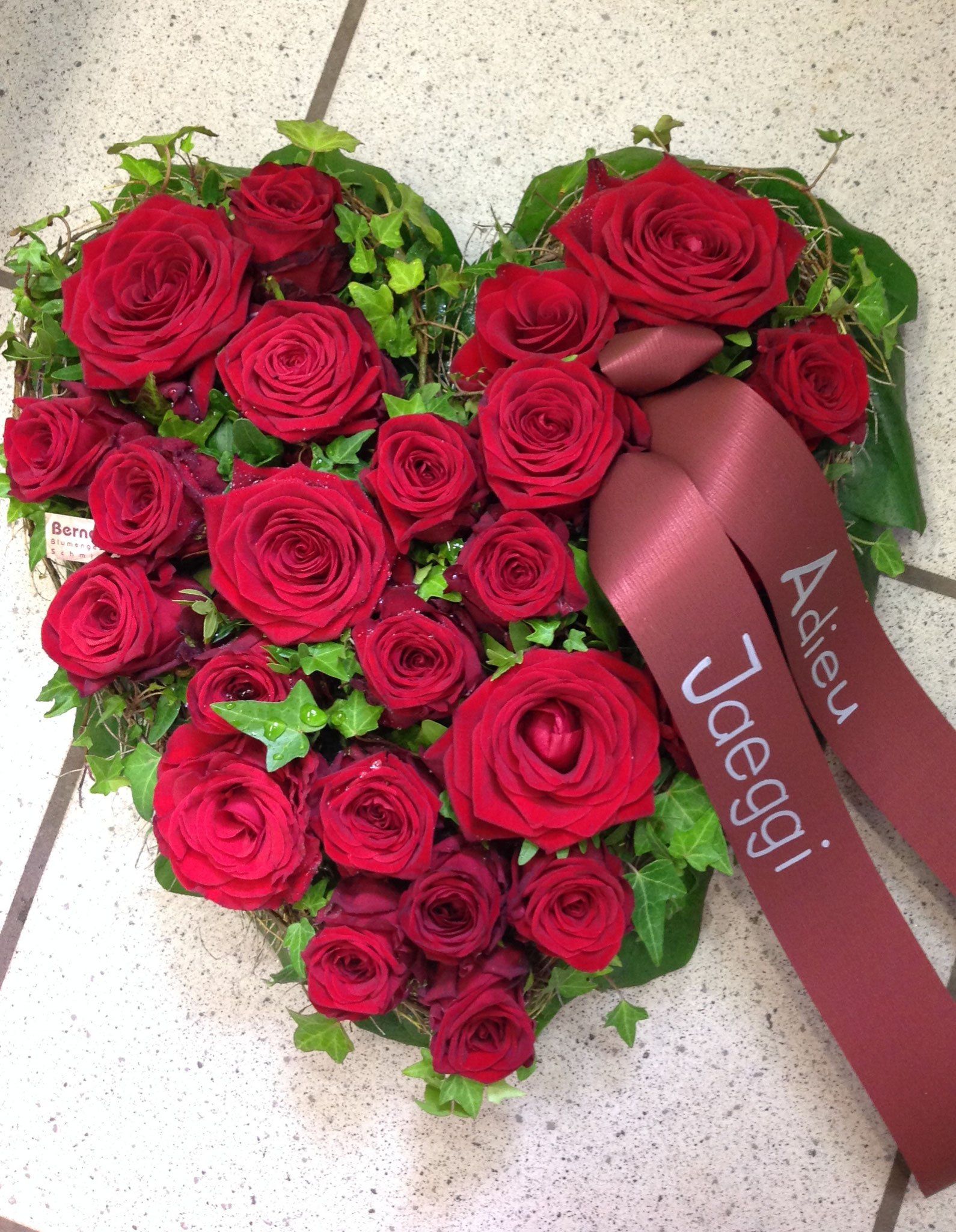 Ein herzförmiger Kranz aus roten Rosen und Grün