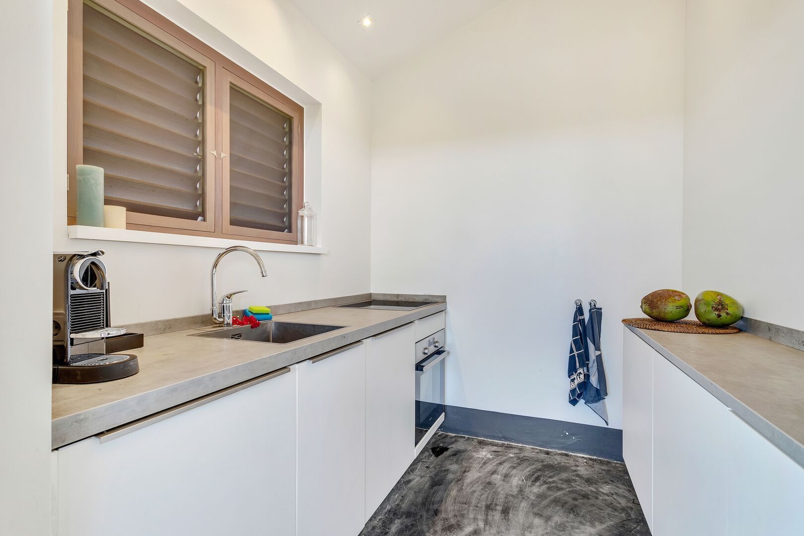 A kitchen with a sink , stove , and window.