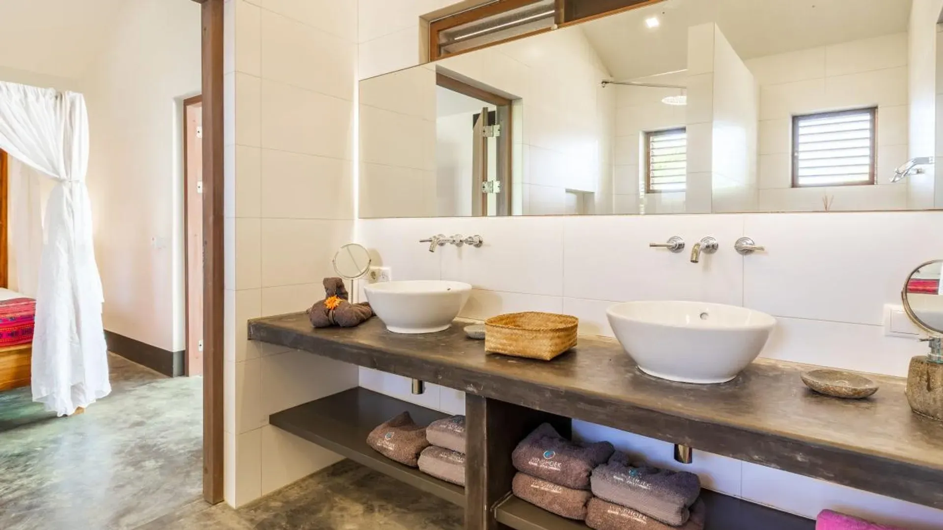 Un baño con dos lavabos y un espejo.