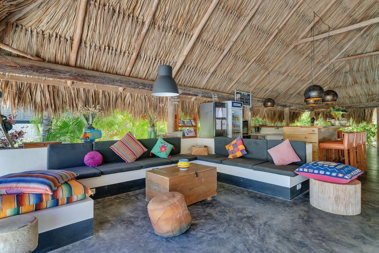 A living room filled with furniture and a thatched roof.