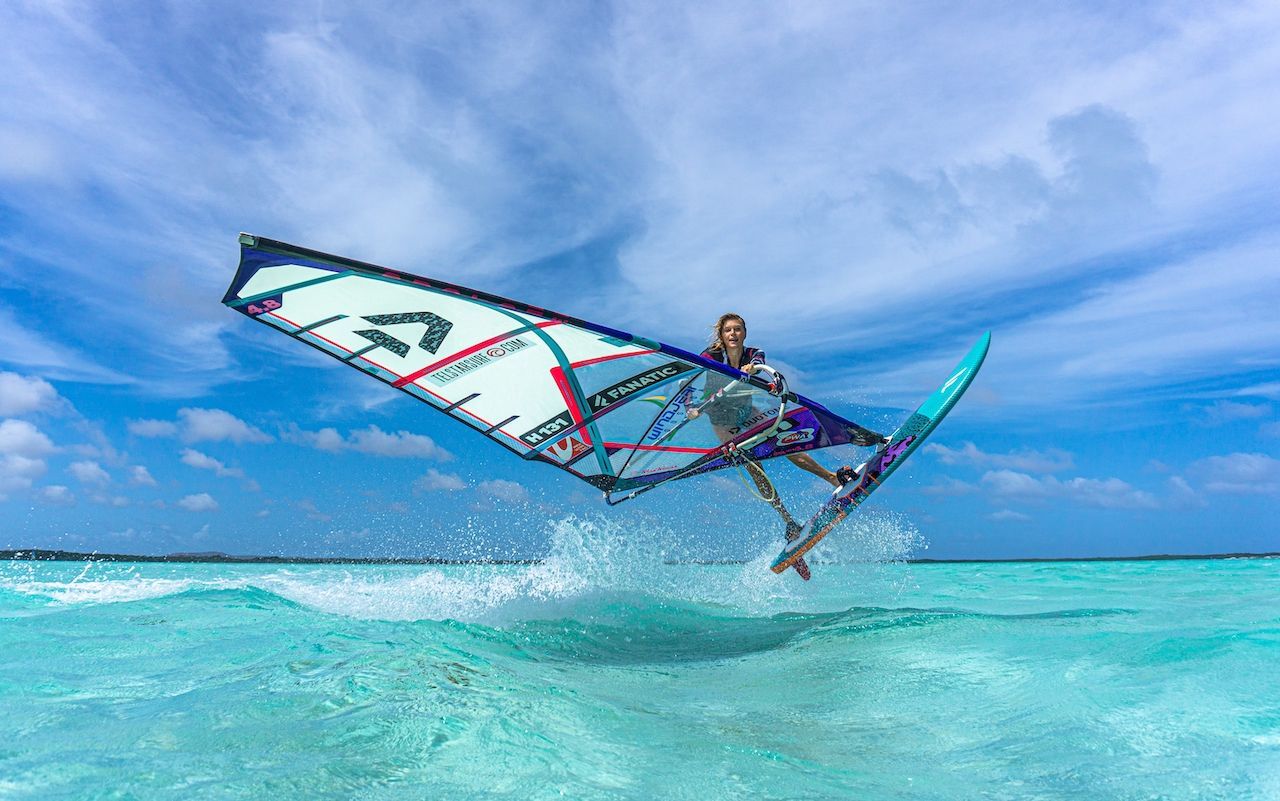 A person is windsurfing in the ocean most beautiful beaches. 