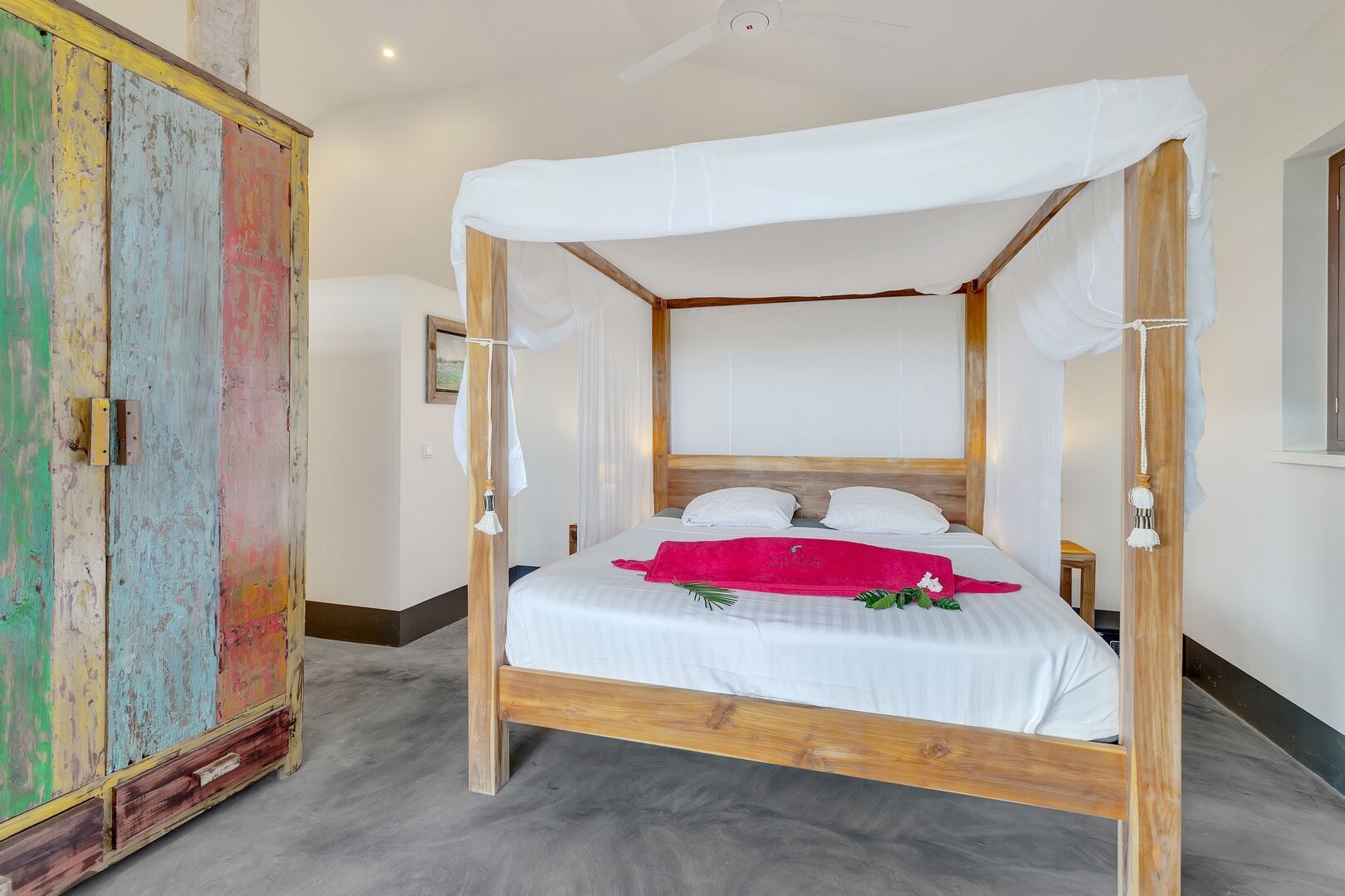 Un dormitorio con una cama con dosel y un armario colorido.