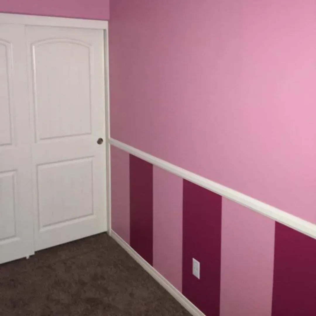 Pink bedroom with striped wainscoting, white closet doors, and brown carpet