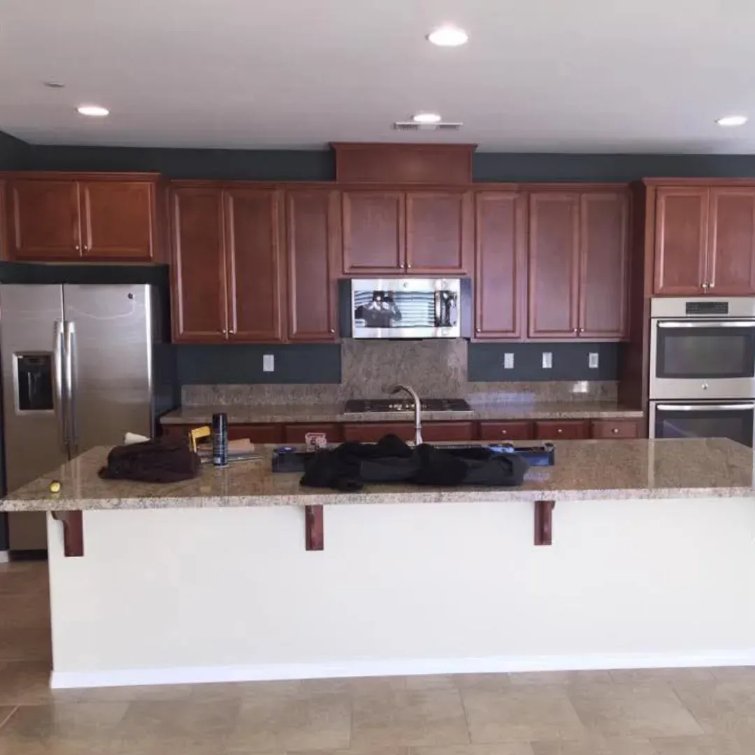 Modern kitchen with wood cabinets, stainless steel appliances, and a granite island countertop