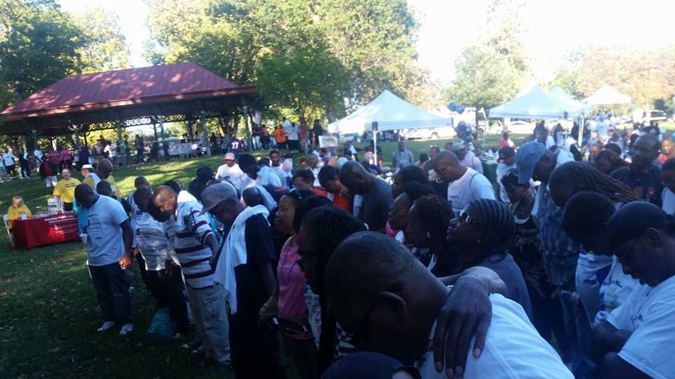 A large group of people are gathered in a park.