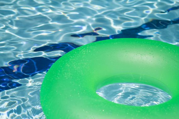 Green pool float in blue rippling water