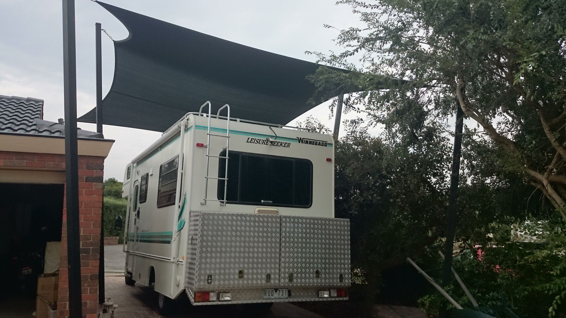 Heavy-duty shade sail installed in Pakenham to protect parked caravans and boats, tensioned over paved hardstand with steel posts, designed to shield against sun exposure, rain, and hail in surrounding south east Melbourne suburbs
