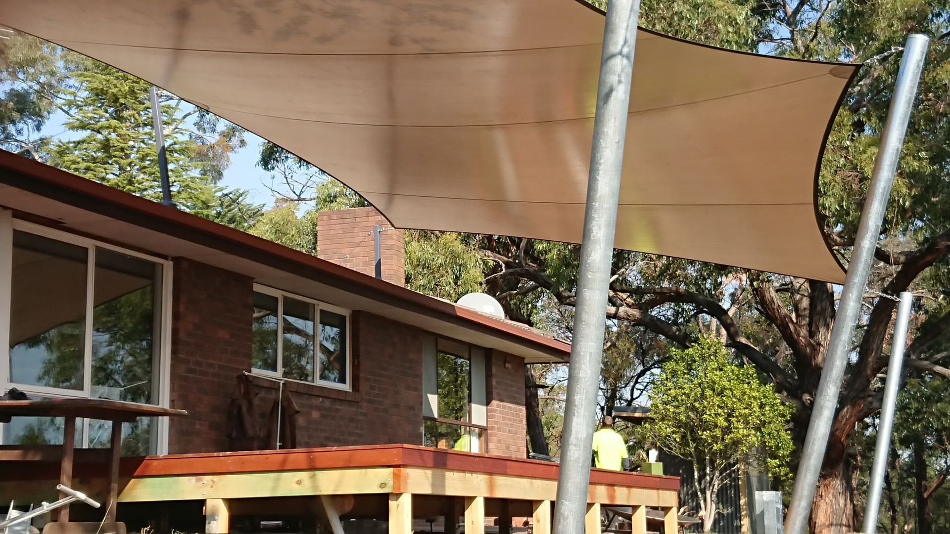 Residential shade sail setup at Rowville 3178 property featuring dual-tone fabric canopies over elevated deck, offering stylish sun shelter above seating area and landscaped backyard