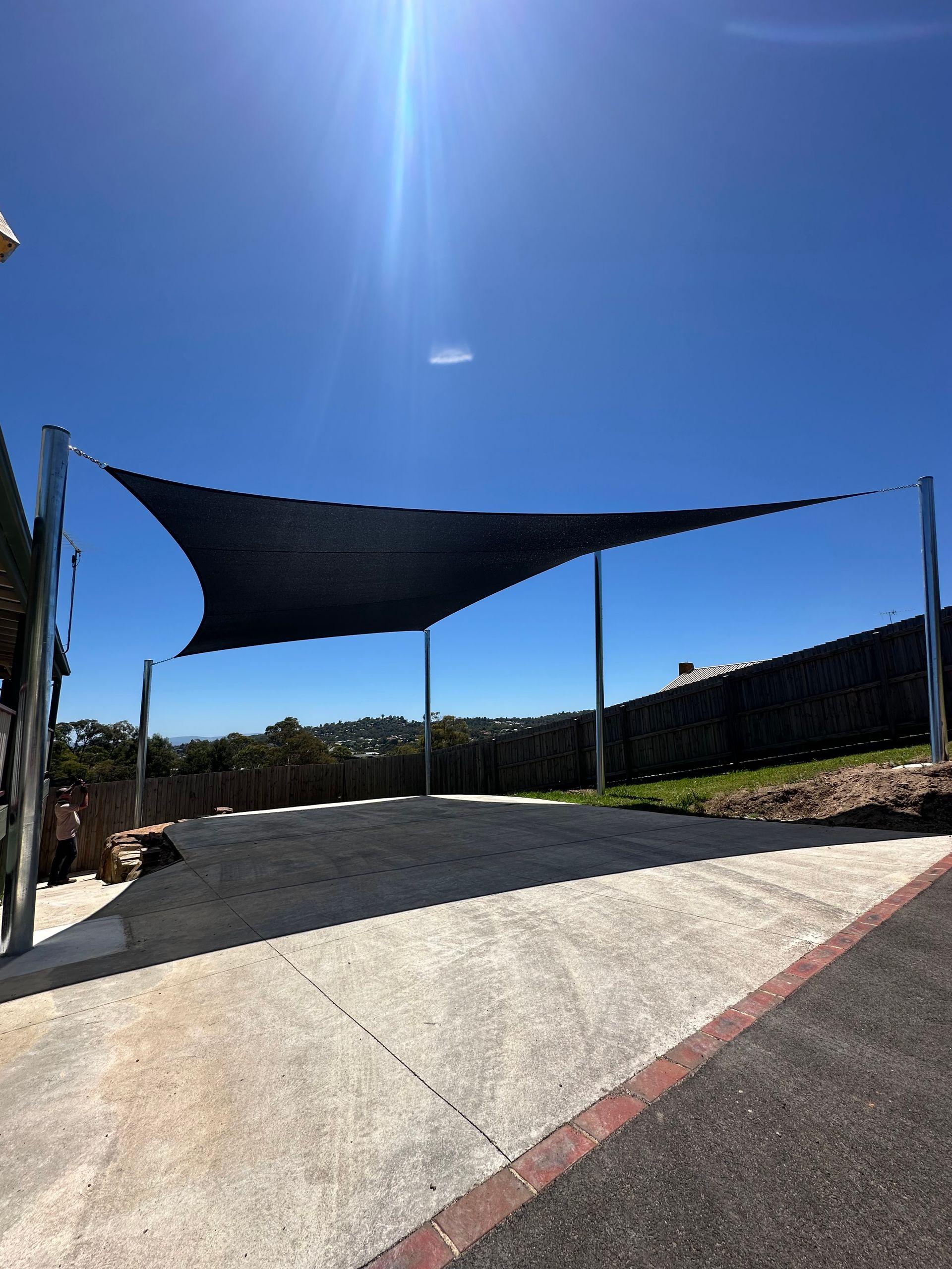 Heavy-duty shade sail installed in Lilydale to protect parked caravans and boats, tensioned over paved hardstand with steel posts, designed to shield against sun exposure, rain, and hail in surrounding south east Melbourne suburbs