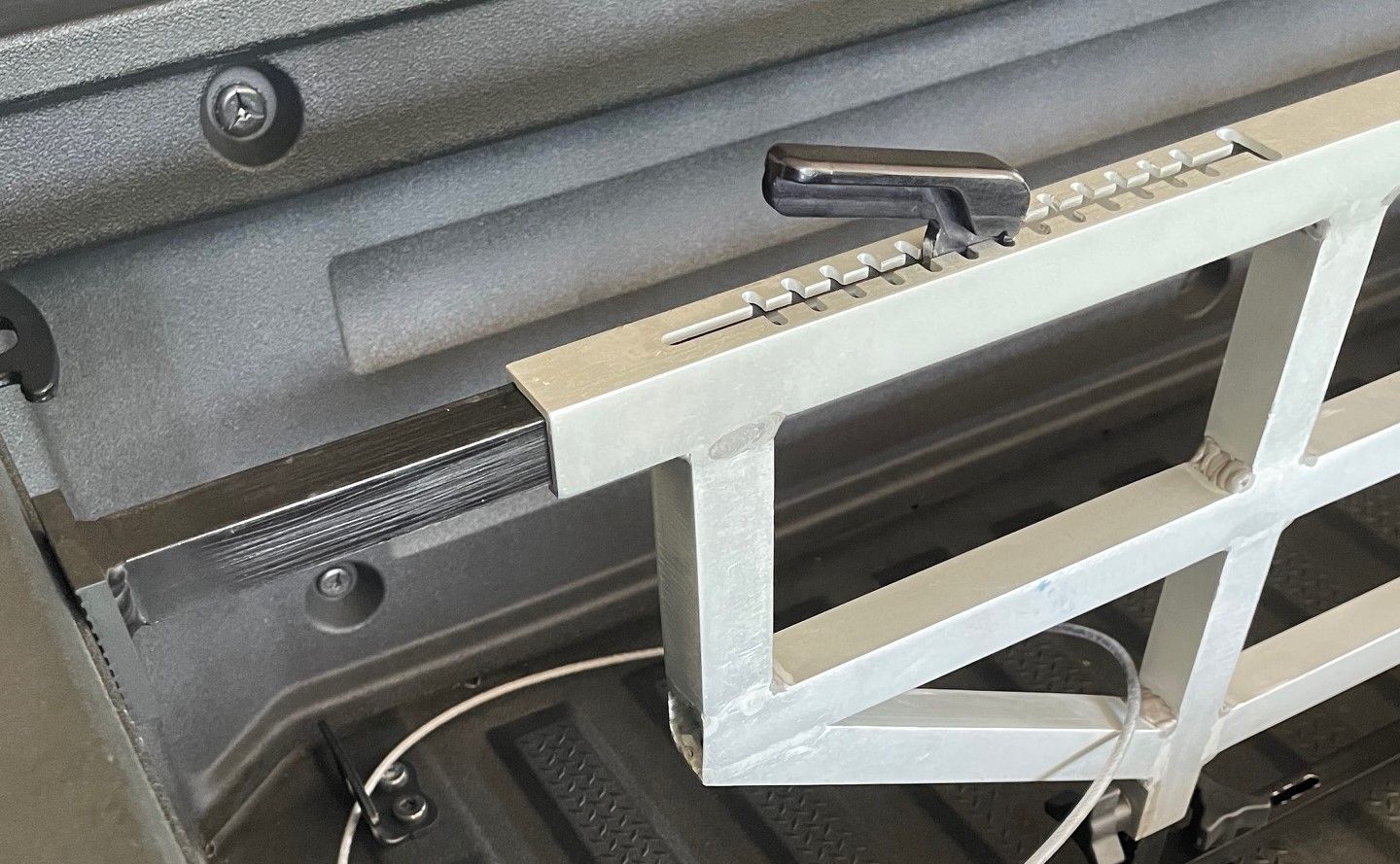 Metal truck bed cargo divider with measuring marks and black details.