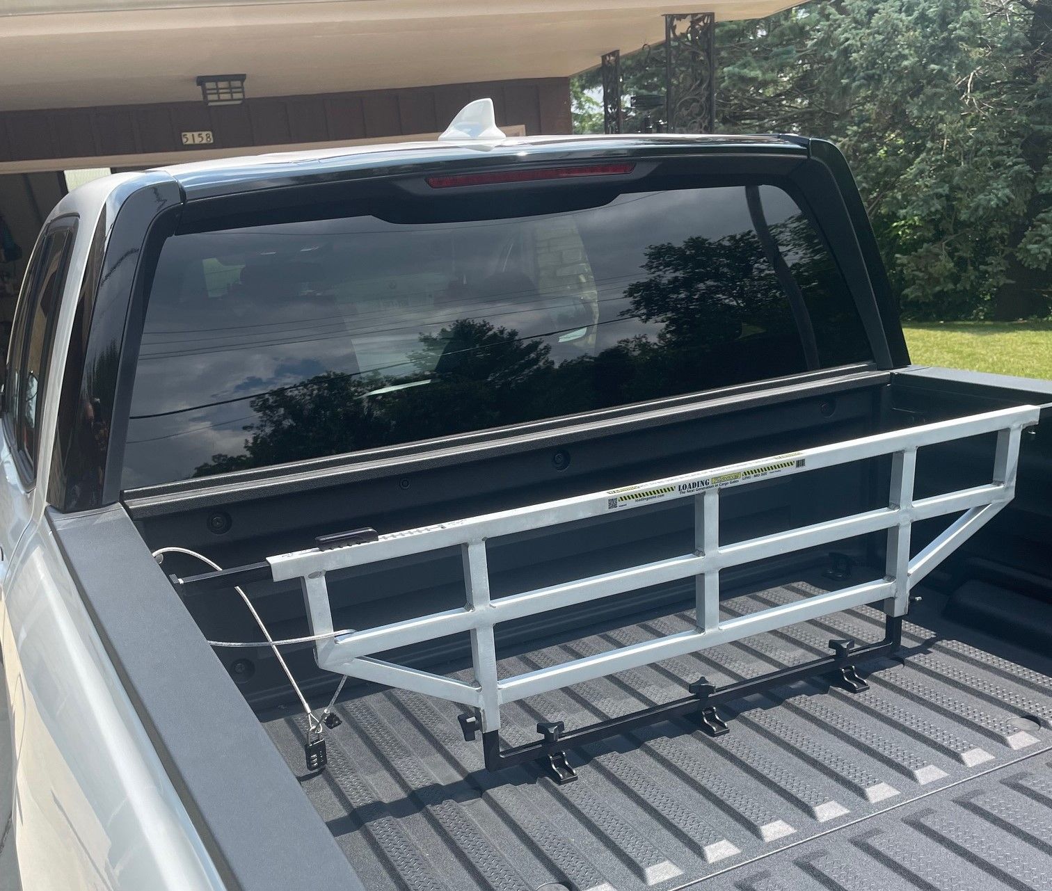 White metal truck bed extender in a pickup truck bed.