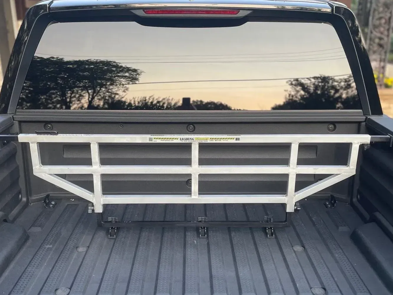 Silver truck bed cargo divider installed in a black truck bed.
