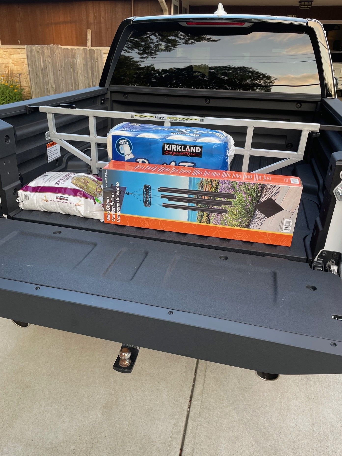 Truck bed with cargo: dog food, water bottles, tripods. Gray frame installed.