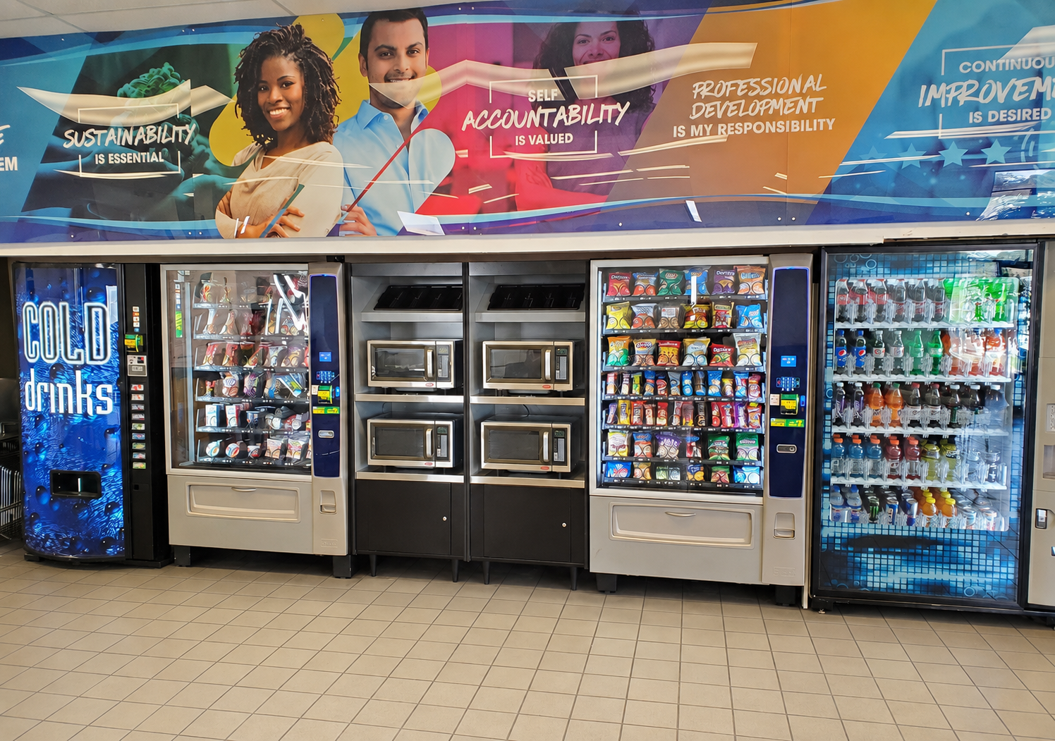 Two glass-front refrigerators stocked with various colorful bottled beverages in a brightly lit, commercial setting.