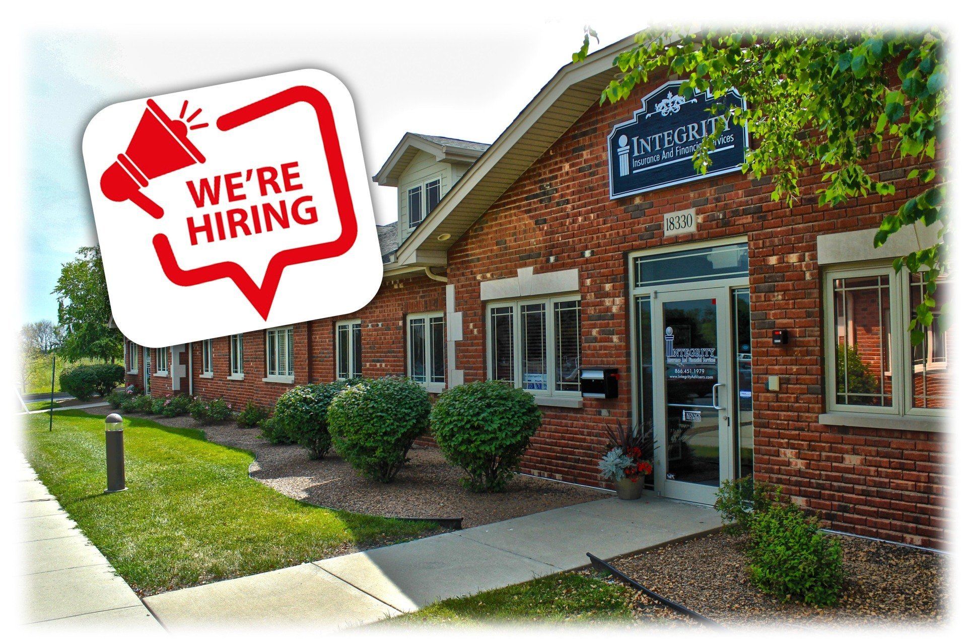 A brick building with a sign that says `` we 're hiring '' next to it.