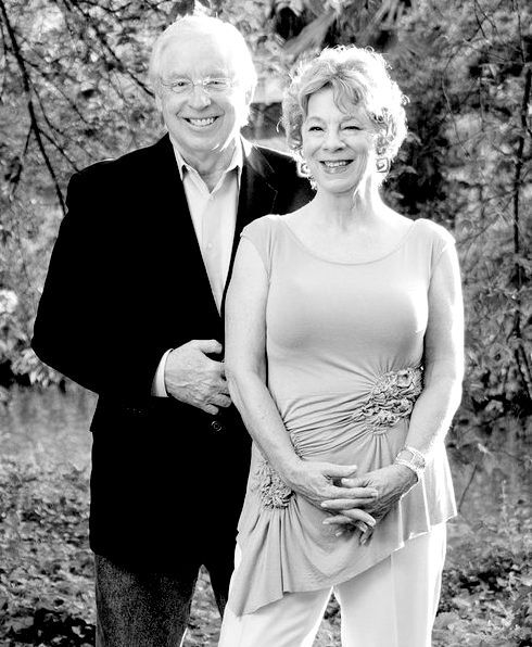 A man and a woman are standing next to each other in a black and white photo.
