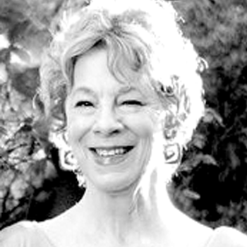 A black and white photo of an older woman smiling.