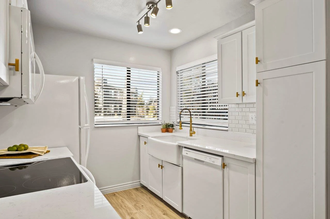 Ascent On Steamboat  kitchen with white cabinets , a stove , a sink , and a window.