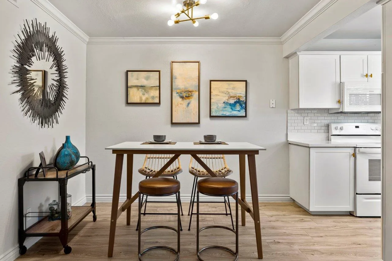 A dining room with a table and stools and a kitchen in the background at Ascent On Steamboat 