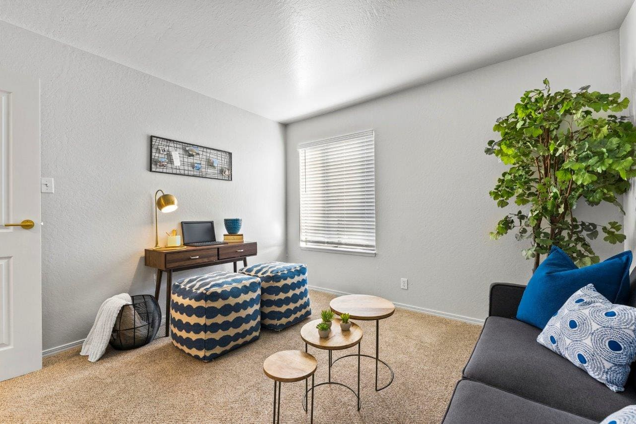 A living room with a couch , ottomans , tables and a desk at Ascent On Steamboat 