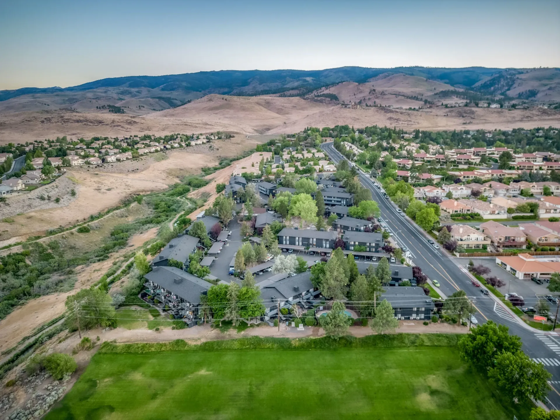 An aerial view of a residential area with mountains in the background.