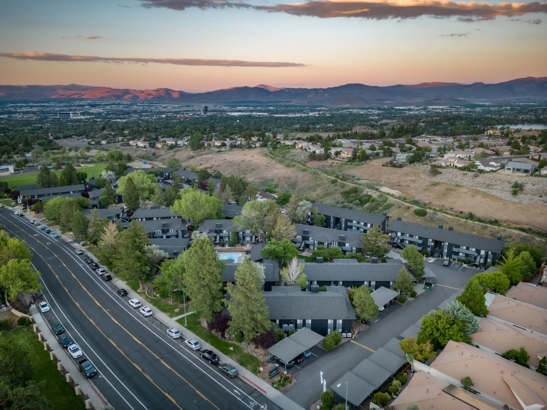 An aerial view of Ascent On Steamboat residential area with a highway and mountains in the background.