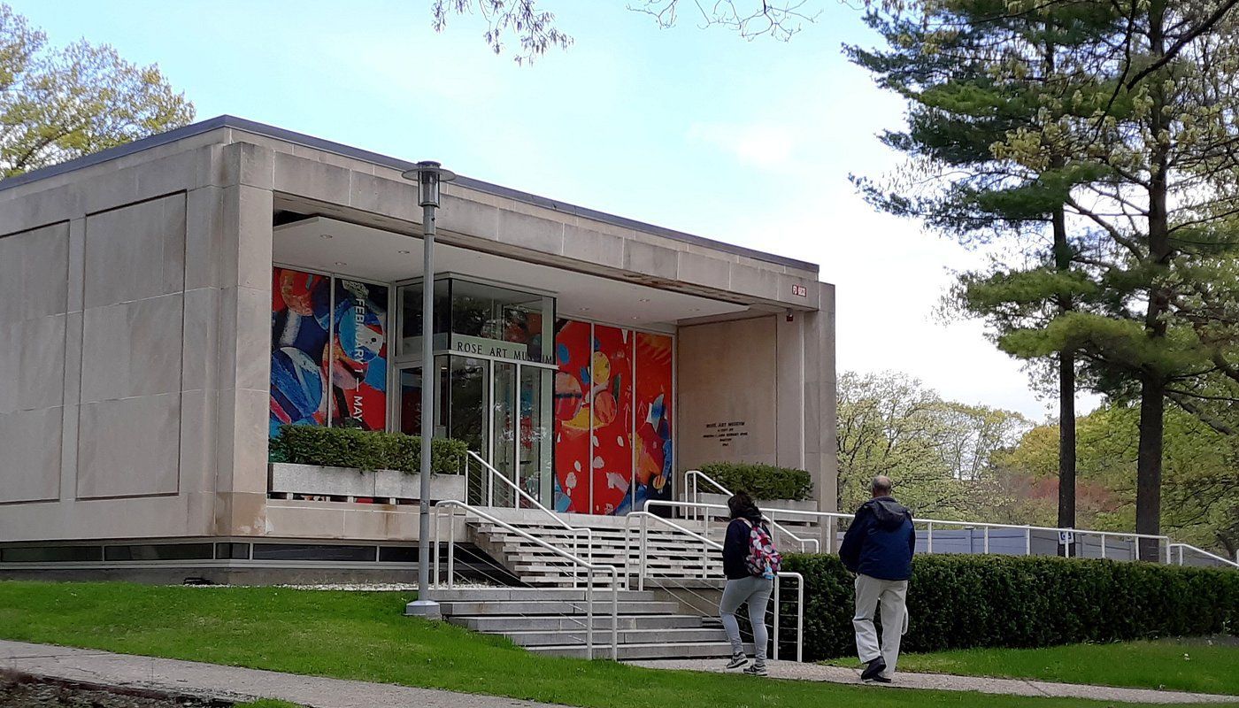 A couple of people are walking in front of a building.