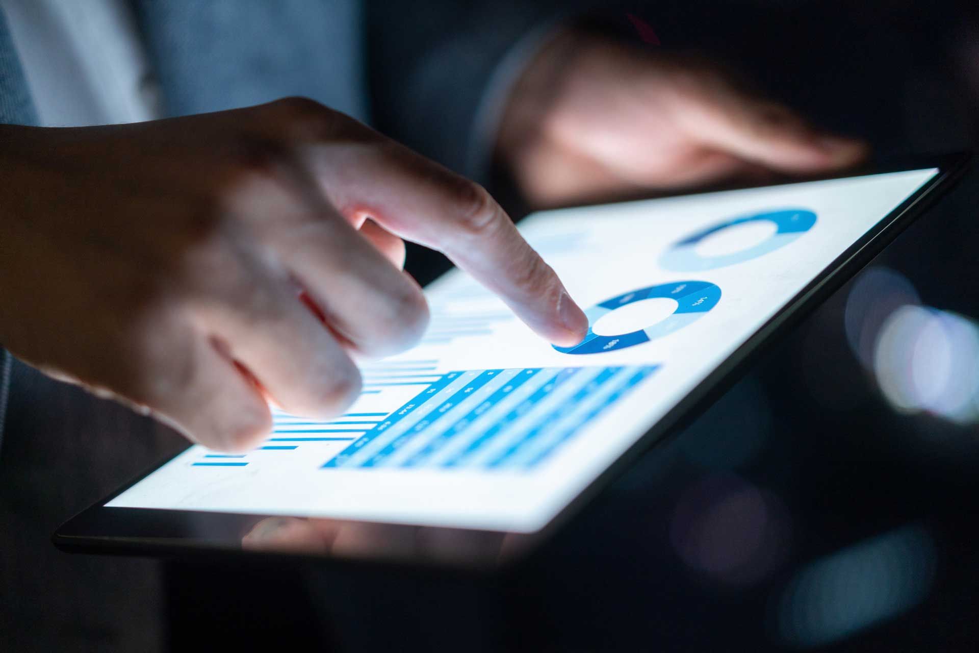A person is pointing at a graph on a tablet.