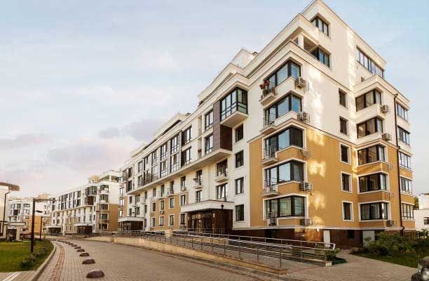 A large apartment building with a lot of windows in a residential area.
