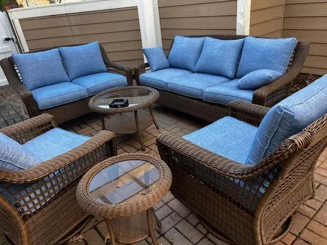 A patio with wicker furniture by Hampton Bay with vibrant blue custom cushions