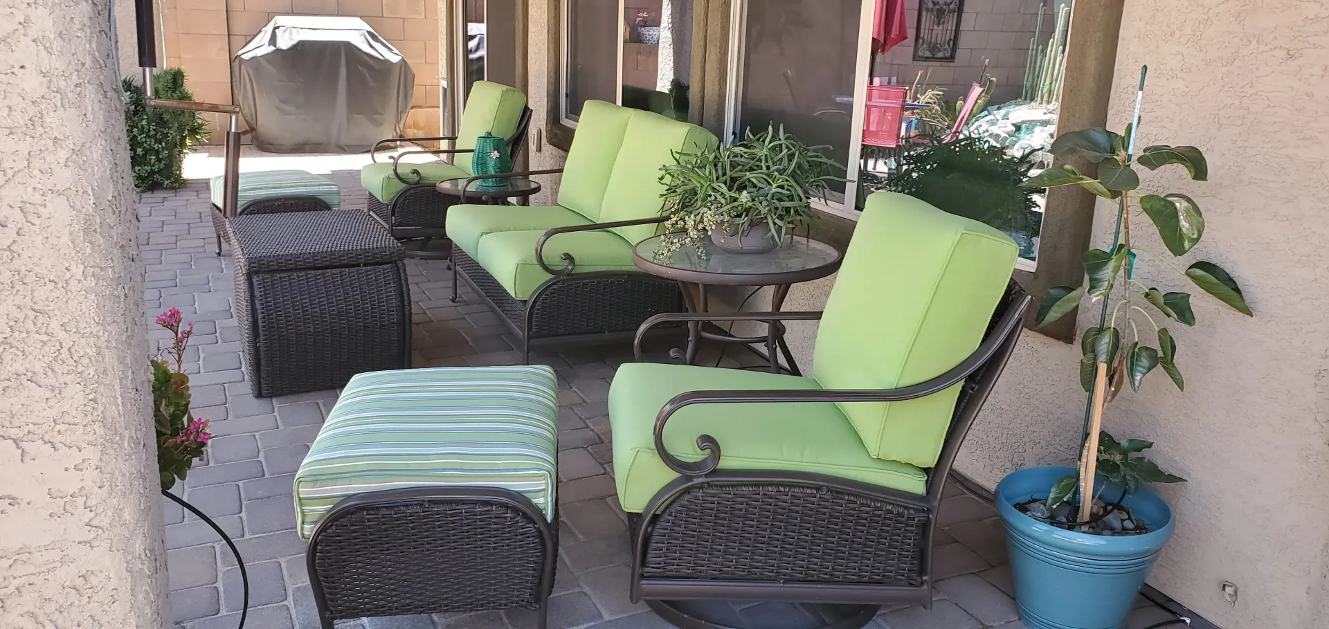 A patio with a lot of furniture and a potted plant.