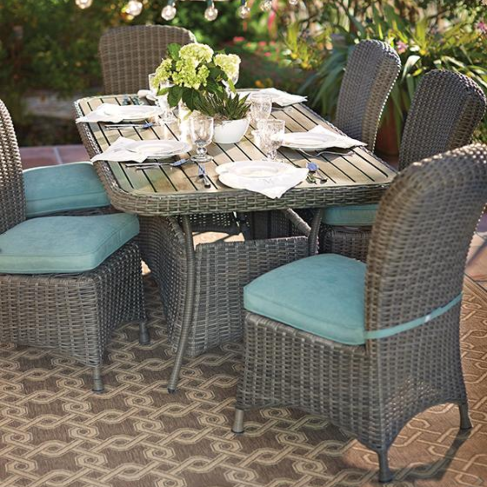A wicker table and chairs set on a rug