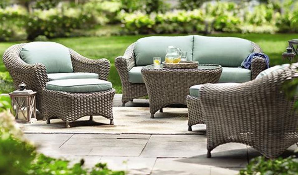 A patio with wicker furniture and a couch and chairs.