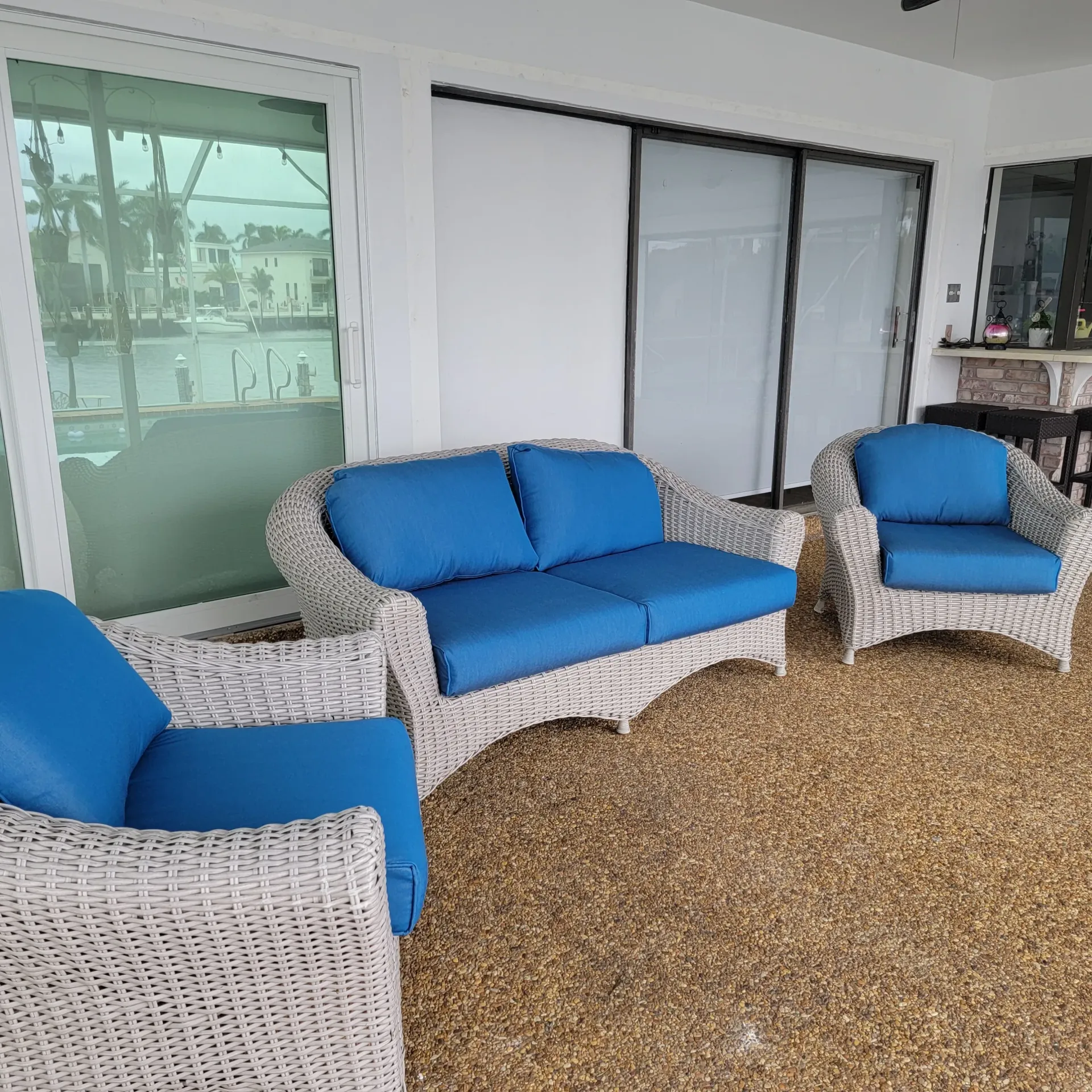 A living room with a couch and two chairs with blue cushions