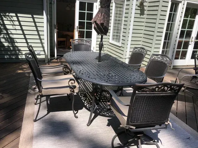 A patio with a table and chairs and an umbrella